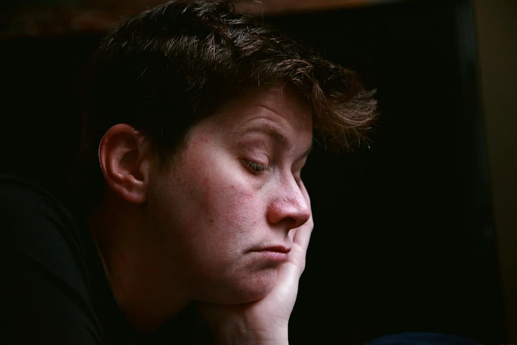 mulher a segurar a cabeça com a mão, com ar cansado e aborrecido