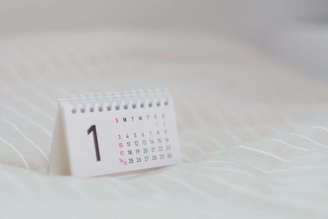 calendário horizontal com argolas em cima de tecido branco
