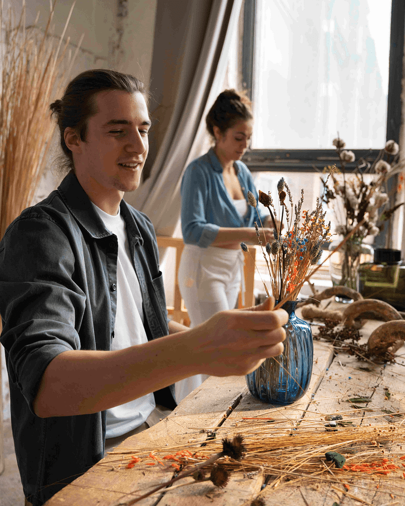 casal jovem a fazer arranjos de flores secas