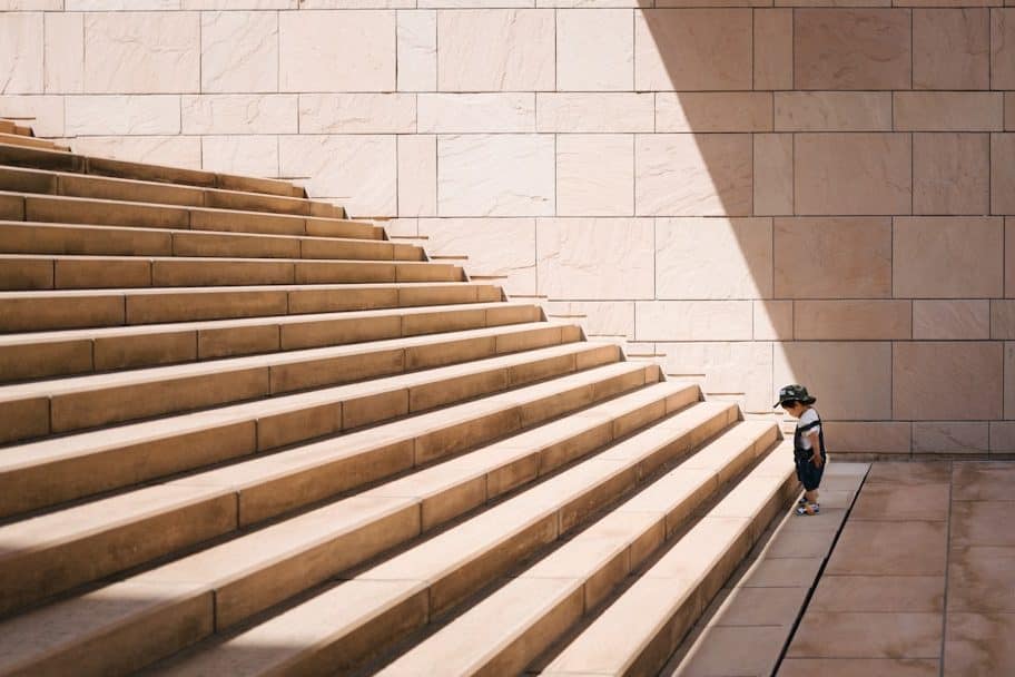 longa e alta escadaria com criança no seu pé.